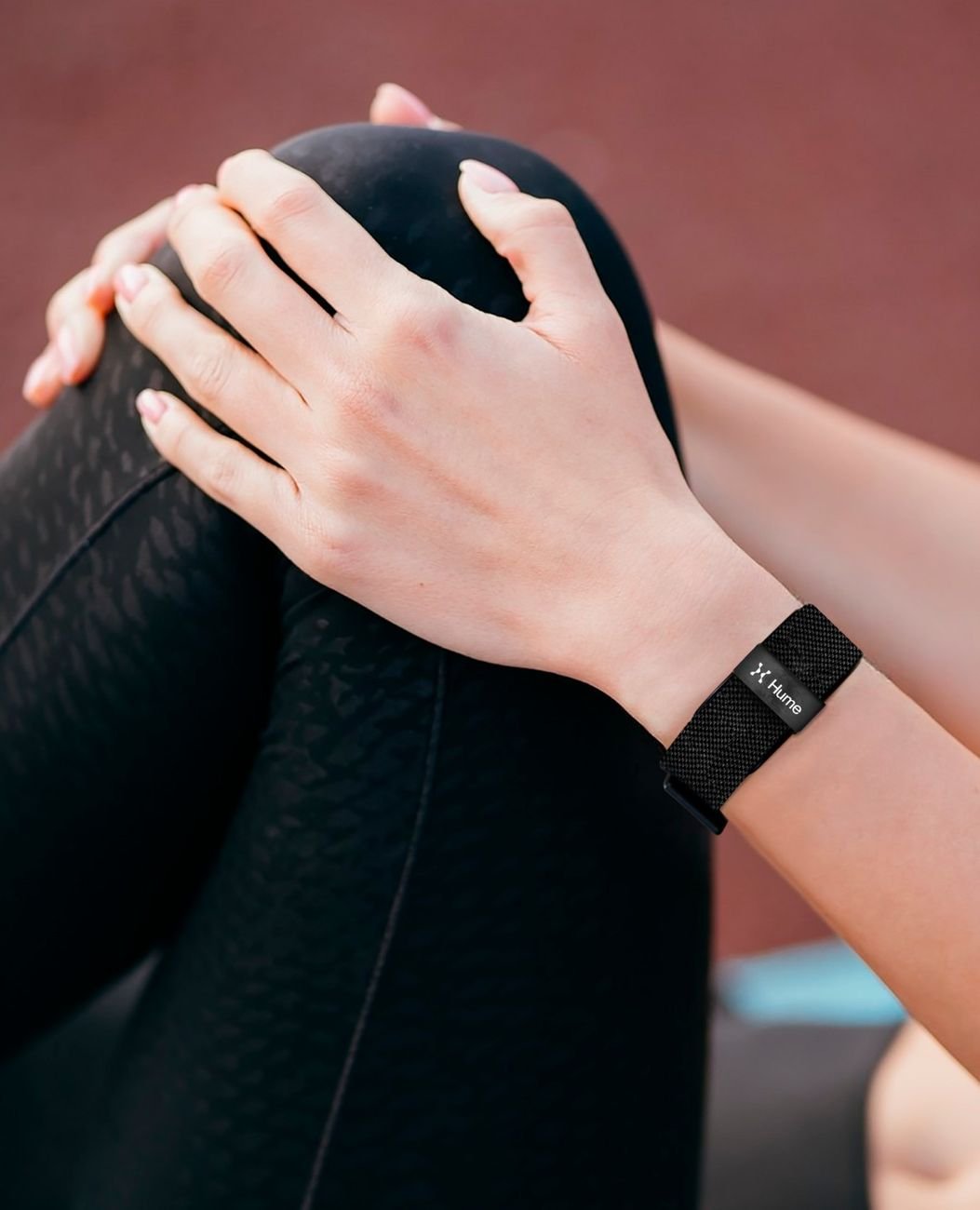 Close-up of hands with Hume Band on the wrist during a stretching routine